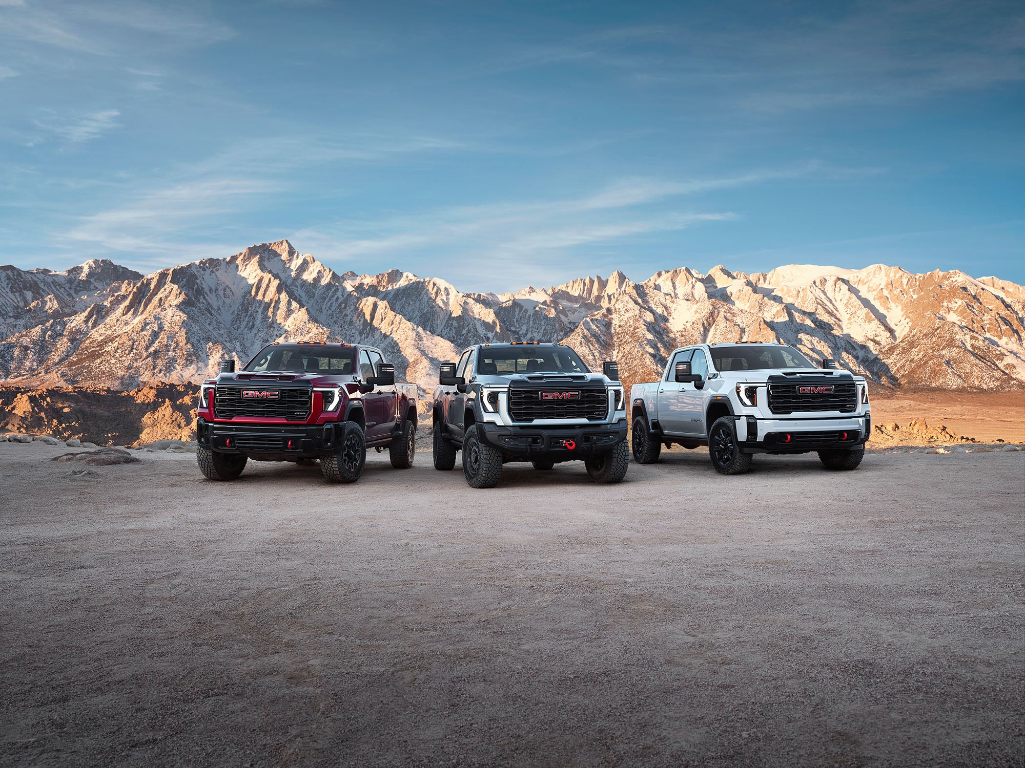Lineup of three new GMC SUVs parked in a misty mountain field available at Anderson Buick GMC of Hunt Valley
